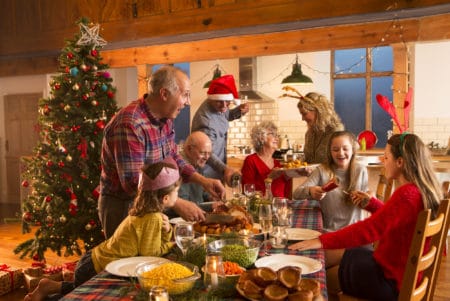 A large family are all helping serve Christmas dinner.
